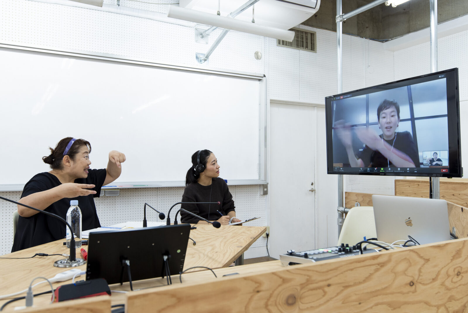 モニターに映っている人と手話で話している配信スタジオの様子