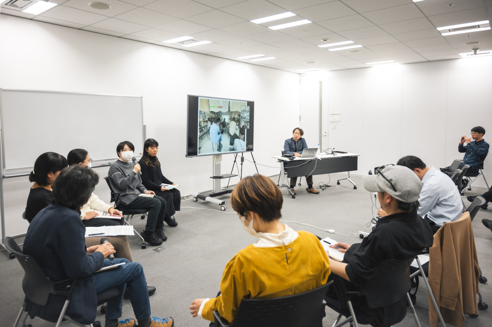 モニターの横に人が並んで座りながら発表している